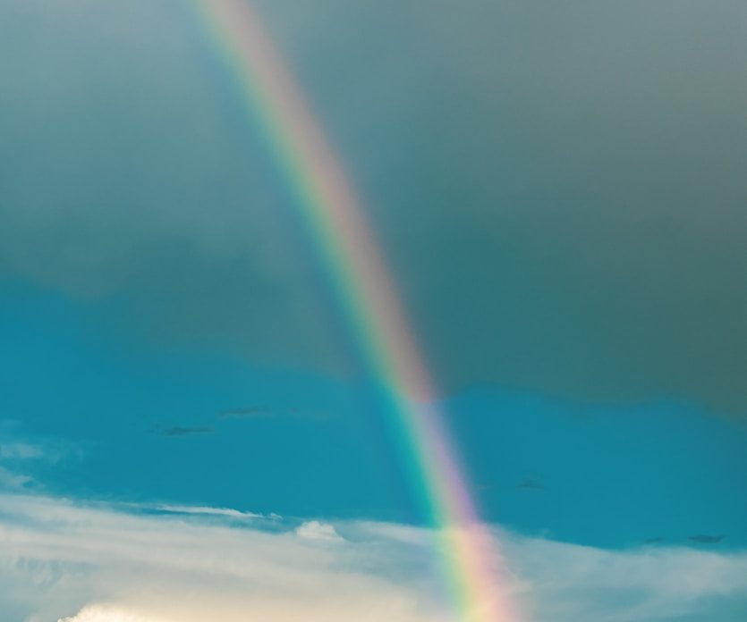 Regenbogen über einer Berglandschaft als Symbol für göttliche Verbindung. 
